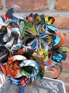 a bunch of paper flowers sitting on top of a blue vase filled with lots of different colors