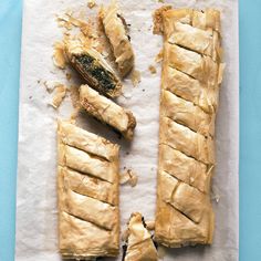 two pieces of bread sitting on top of a piece of paper next to a knife