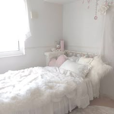 a bedroom with white walls and fluffy bedding