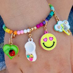 the bracelets are decorated with different designs and colors on each one hand, including an embellished smiley face