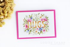 a card with the word hugs on it next to some flowers and pineconi