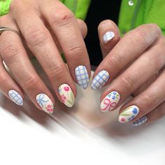 These nails feature a delightful summer design with a mix of pastel blue checkered patterns and playful floral accents in pink, blue, and green. The vibrant colors and whimsical flowers perfectly capture the essence of a sunny summer day.  🌸Click on the image to shop our trending Korean Gel Polish this season.  🌸Credit: nails.byliz on Instagram 🌸summer nails, floral nails, pastel nails, checkered nails, Korean gel polish, summer nail art, trendy nails, nail inspiration, Instagram nails, bright nail colors, summer manicure, nail fashion, flower nails, nail trends, summer beauty, colorful nails, gel polish, hand-painted nails, seasonal nail art, summer vibes nails Nail Designs With One Accent Nail, Pastel Gel Nails Ideas, Sue Bagley Nails, Fun Pastel Nails, Light Blue Flower Nails, Colorful Pastel Nails, Blue Checkered Nails, Summer Nails Floral, Checkered Nail Designs