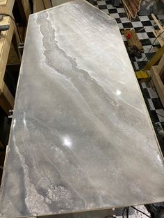 a table that has some kind of silver marble on top of it and is being worked on