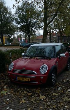 a small red car parked in front of some trees