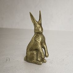 a gold colored rabbit figurine sitting on its hind legs