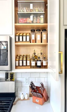 a kitchen with white cabinets and shelves filled with food