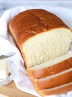 a loaf of bread sitting on top of a cutting board next to butter and a knife