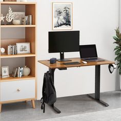 a computer desk with a laptop on top of it next to a bookshelf