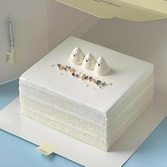 there is a cake with three white birds on the top and two smaller ones in the middle