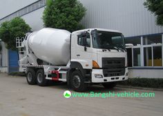 a white cement truck parked in front of a building