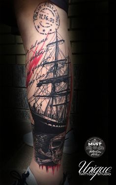 a man's leg with a ship on it and ink splattered in red