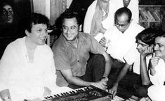 a group of people sitting around an old fashioned keyboard