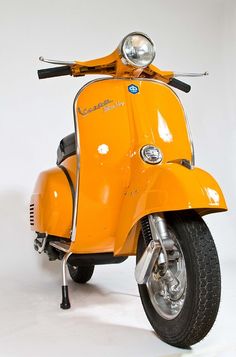 an orange motor scooter is parked on a white background and it's front wheel still attached to the seat