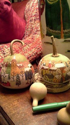 two ceramic pumpkins sitting on top of a wooden table next to a green marker