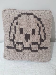 a decorative pillow made out of knitted yarn with black and white designs on it