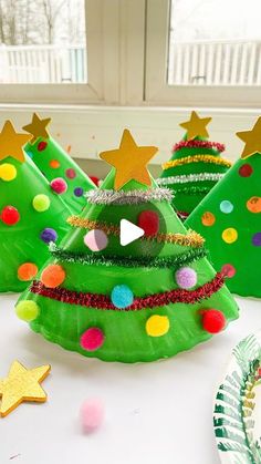 paper plate christmas trees are sitting on a table with other decorations and confetti