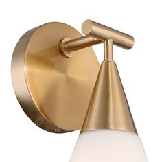 a brass wall light with a white glass shade on the top and an angled arm