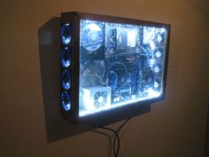 a wall mounted computer case with many different parts on it's sides and some wires attached to the back