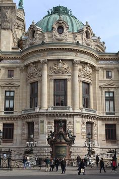 people are walking around in front of an old building