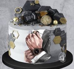 a cake decorated with an image of a man's hand holding a watch and other items