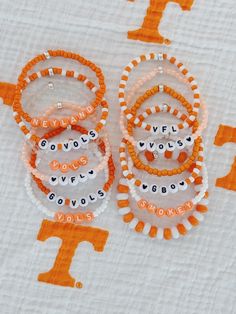 orange and white beaded bracelets with words on them