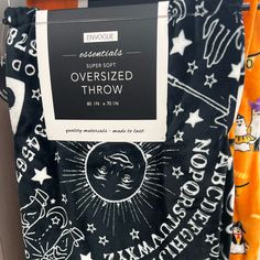 the back of an orange and black blanket with white stars on it in front of a store display