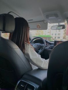 a woman sitting in the driver's seat of a car