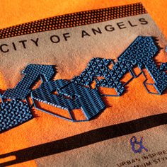 the city of angels logo is shown on an orange shirt