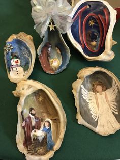 four nativity figurines in shell shells on a green tableclothed surface