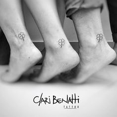 three people with tattoos on their feet standing next to each other and holding hands together