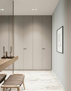 an empty room with two chairs and a table in it, next to some cabinets