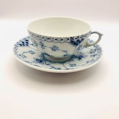 a blue and white tea cup with saucer