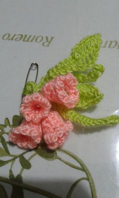 a crocheted flower is sitting on top of a book