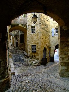 an alley way with stone buildings and cobblestones