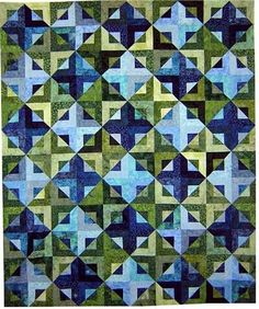 a blue and green quilt with many squares on the front, one in the middle