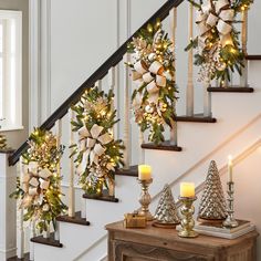 christmas decorations on the banisters and stairs with lit candles in front of them