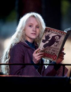 a woman with long blonde hair reading a magazine