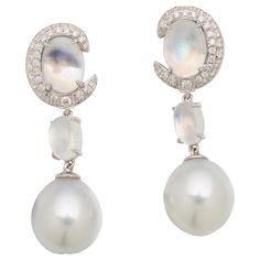 This earring in inspired by the Moonstones. The top part of the earring is a Moonstone engulfed by a Diamonds encrusted Moon Crescent followed by a Moonstone Cabochon and at the bottom dangling a White Australian South Sea Pearl. The base tone of this earring is white and silver with a touch of colour play displayed by the refraction of the moonstone and pearls. It is a very elegance everyday piece suitable for all occasion. It consists of A pair drop Shape South Sea Pearl with Excellent Lustre Luxury Moon Shaped Jewelry For Formal Occasions, Elegant White Crescent Earrings, Elegant Moon-shaped Wedding Earrings, Celestial Style Round Formal Earrings, Celestial Round Earrings For Formal Occasions, Celestial Style Round Earrings For Formal Occasions, Formal Celestial Round Earrings, Elegant Moon Shaped Wedding Earrings, Elegant Moon-shaped Jewelry With Matching Earrings