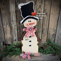 a snowman with a black hat and red plaid bow