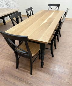 a wooden table with black chairs around it