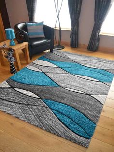 a living room with a blue and gray rug on the floor next to a black chair