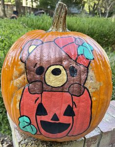 a painted pumpkin with a teddy bear on it