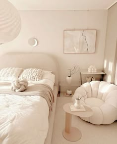 a white bedroom with two chairs and a bed in the corner, one chair is shaped like an elephant