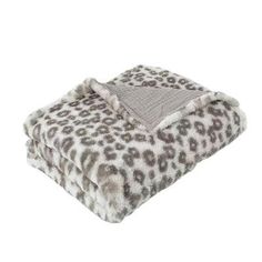 the leopard print blanket is folded up on top of a white background with grey and black spots