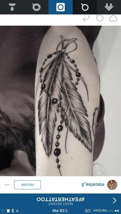 a woman's arm with a feather and beads tattoo on it