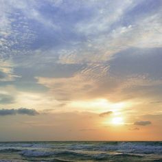 the sun is setting over the ocean with waves