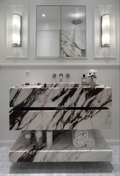 a bathroom with marble counter tops and two mirrors on the wall, along with double sinks