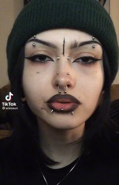 a woman with piercings on her face and nose