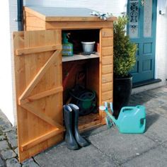 a garden shed with its door open and gardening tools outside