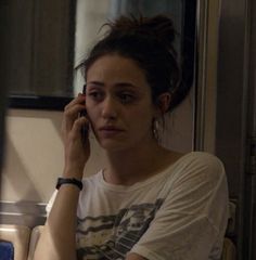 a woman talking on a cell phone while sitting down